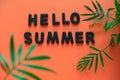 flat lay inscription hello summer and tropical palm leaves frame orange background Royalty Free Stock Photo