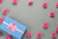 luxury blue present box with festive pink satin ribbon bow and delicate pink roses pattern frane on a gray Royalty Free Stock Photo