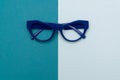 Top view flat lay, modern blue eye glasses on pastel paper background Royalty Free Stock Photo