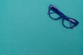 Top view flat lay, modern blue eye glasses on pastel paper background Royalty Free Stock Photo