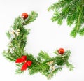 Top view flat lay natural Christmas tree branches with red toys, bow and glass reindeer corner frame on bright background. New yea Royalty Free Stock Photo