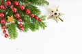 Top view flat lay natural Christmas tree branches with red toys, bow and glass reindeer corner frame on bright background. New yea Royalty Free Stock Photo