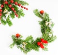 Top view flat lay natural Christmas tree branches with red toys, bow and glass reindeer corner frame on bright background. New yea Royalty Free Stock Photo