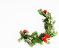 Top view flat lay natural Christmas tree branches with red toys, bow and glass reindeer corner frame on bright background. New yea Royalty Free Stock Photo