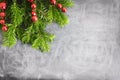 Top view flat lay natural Christmas tree branches with red toys, bow and glass reindeer corner frame on chalkboard background. New Royalty Free Stock Photo