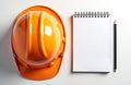 Top view flat lay orange hard hat safety helmet, blank notepad, and pencil on white table. Object for building, planning, and Royalty Free Stock Photo