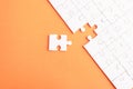 Top view flat lay of paper plain white jigsaw puzzle game texture last pieces for solve and place, studio shot on an orange backgr Royalty Free Stock Photo
