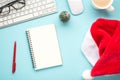 Top view flat lay photo of santa claus hat keyboard computer mouse red pen organizer glasses pine toy and cup of hot drinking on Royalty Free Stock Photo