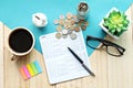 Top view or flat lay of piggy bank, saving account book or financial statement and coins on office desk table Royalty Free Stock Photo