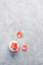 Top view flat lay Pink rose in white vase with petals on bright grey background Royalty Free Stock Photo