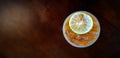 Flat lay of plastic glass of iced lemon tea with sliced lime or lemon on top isolated on dark wooden background Royalty Free Stock Photo