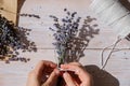 Top view flat lay of process making bouquets of dried lavender flowers. Cotton rope, scissors. Female do homemade herbs Royalty Free Stock Photo