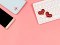 Flat lay of red glitter heart on compuer keyboard , mobile phone and passport cover on pink background with copy space ,long Royalty Free Stock Photo