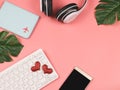 Flat lay of red glitter heart on computer keyboard , mobile phone, headphones and passport cover on pink background with copy Royalty Free Stock Photo