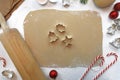 Top view flat lay of rolled out cookie dough with rolling pin, seasonal cookie cutters and Christmas decoration Royalty Free Stock Photo