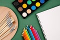 Top view, flat lay of a set of watercolors, wooden palette with different types of paint brushes, colorful pencils and blank Royalty Free Stock Photo