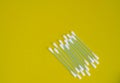 Top view, flat lay, a small group of pink plastic cotton swabs neatly arranged on a yellow background, the concept of cleanliness Royalty Free Stock Photo