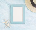 Top view flat lay summer mockup: empty blue photo frame, straw hat and starfish on blue background. Vacation concept. Space Royalty Free Stock Photo