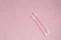 Top view, flat lay, two pink plastic cotton swabs neatly arranged on a pink background, the concept of cleanliness and hygiene Royalty Free Stock Photo
