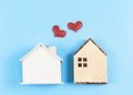 Flat lay of two wooden model houses with red glitter hearts on blue background. dream house , home of love, strong relationship, Royalty Free Stock Photo