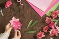 Top view, flatlay. Woman making paper flowers for valentines, woman`s day or holiday concept