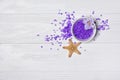 Flavored purple sea salt crystals with violet flower and starfish on white