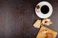 top view of flour cookies with strawberry jam on a wooden board and pieces of sesame kozinaki and a cup of coffee on black Royalty Free Stock Photo