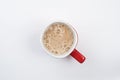 Top view of foamy milk coffee or milk tea in a red mug