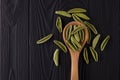 Top view of foglie spinach pasta on black wooden table with spoon Royalty Free Stock Photo