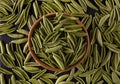 Top view of foglie spinach pasta in bowl and scattered on black wooden table Royalty Free Stock Photo