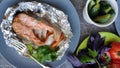 Top view of foil baked salmon steak and fresh vegetables, selective focus