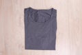 Top view folded gray t-shirt on wooden background