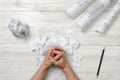 Top view of folded hands man on wooden surface with architect drawing Royalty Free Stock Photo