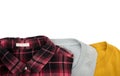 Top view folded T shirts and plaid shirt isolated on white background