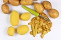 Top view of food preperation with peeled potatos, peels and whole potatoes