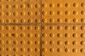 Top view of footpath tiles Yellow circle buttons pattern. A stop signal for blind person Solid square background Royalty Free Stock Photo