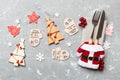 Top view of fork and knife tied up with ribbon on napkin on cement background. Close up of christmas decorations and New Year tree