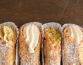 Top view of four delicious cannoli on wooden background Royalty Free Stock Photo