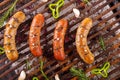 Top view of four grilling sausages on barbecue grill with some species. BBQ in the garden. Bavarian sausages Royalty Free Stock Photo