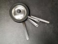 Top view of four stainless steel pans on the dark gray concrete floor