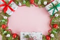 Top view on a frame from red, green and silver Christmas decorations, gift boxes and fir branches on a pink background. Royalty Free Stock Photo