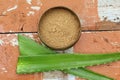 Top view of fresh aloe vera leaves and a bowl of powder on the table