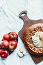 top view of fresh apples and homemade apple pie on wooden cutting board Royalty Free Stock Photo