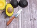 Top view of the fresh avocado half and knife on a wooden table. Royalty Free Stock Photo