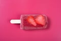 Top view fresh Brazil berry flavor popsicle with strawberry slices on a rose red background