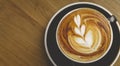 Top view of fresh brewed coffee with beautiful latte art on wooden table in cafe with copy space. Coffee break recreation Royalty Free Stock Photo