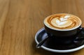 Top view of fresh brewed coffee with beautiful latte art on wooden table in cafe with copy space. Coffee break recreation Royalty Free Stock Photo