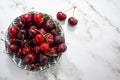 Top view of fresh cherries on bowl on marble background with copy space Royalty Free Stock Photo