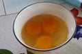 Top view, fresh cracked eggs in white ceramic cup, breakfast cooking concept