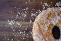 Top view of fresh doughnut with sugar around on wooden table